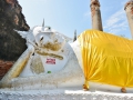 People put gold strips on the reclining buddha in Ayutthaya, Thaialand.
